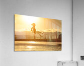3 year old girl jumps into the sea at sunset. Acrylic Print