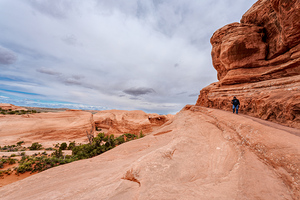 Man Hiking Narrow Ledge Delicate Arch