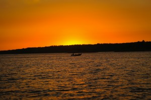 SUNSET AND BOAT BY THE WATER