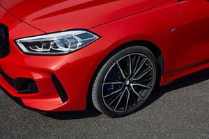 The headlight and wheel of the BMW M135i . 