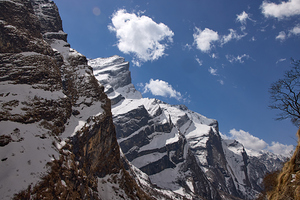 Snow-covered mountains are visible on a sunny day along the trekking path to Annapurna Base Camp in Nepal