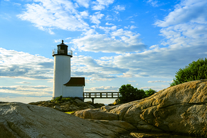 Setting Sun Illuminates Rocky Shore By Annisquam Harbor Light in Massachusetts