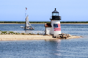 Sailboat Passes Brant Point Lighthouse on Nantucket Harbor in Massachusetts