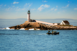 Fishing Boat Passes White Island Isles of Shoals Lighthouse in New Hampshire
