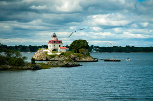 Seagulls Fly Around Sunlit Pomham Rocks Light in Rhode Island
