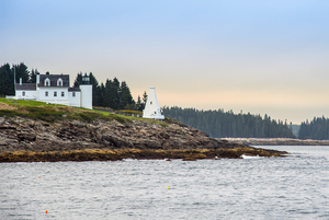Setting Sun Breaking Through Clouds Over Tenants Harbor Light in Maine