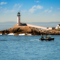 Fishing Boat Passes White Island Isles of Shoals Lighthouse in New Hampshire