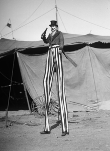 1930s SMILING CLOWN ON STILTS DRINKING FROM BOTTLE 176687