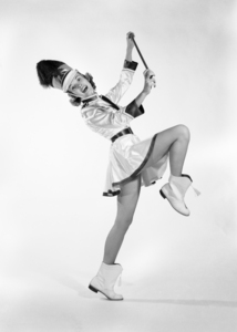 1960s MAJORETTE MARCHING ONE LEG UP HOLDING BATON 195431