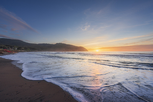 Waves on the Baratti beach at sunset. Tuscany Italy