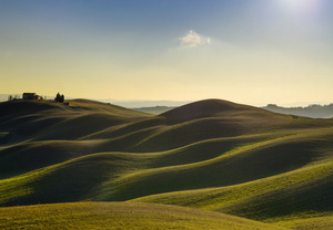 Tuscany sunset landscape. Rolling hills and farm.