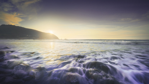 Waves on Baratti beach at sunset. Tuscany