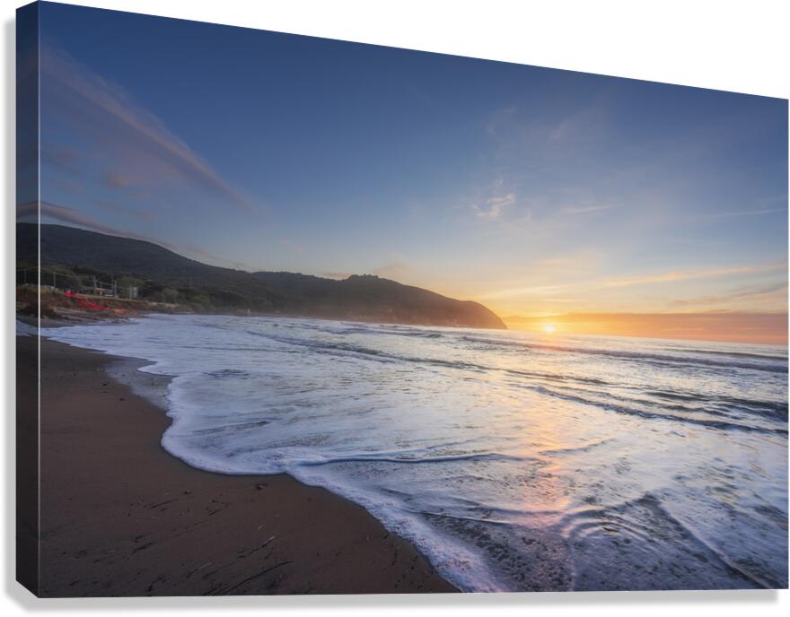 Waves on the Baratti beach at sunset. Tuscany Italy Canvas Print