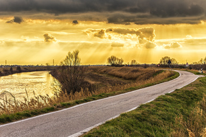 Sunset on road along river 
