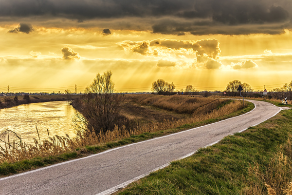 Sunset on road along river  by Vivida Photo PC