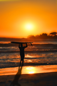 Surfer at sunset Ventura Beach