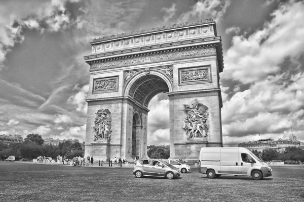 Arc de Triomphe in Paris captured in a dramatic black and white photograph. by IB Photography