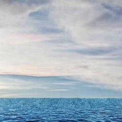 A serene ocean scene featuring the expansive sky and calm waters creating a peaceful atmosphere.