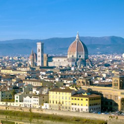 Florences iconic Duomo dominates the cityscape on a bright beautiful day showcasing its beauty.