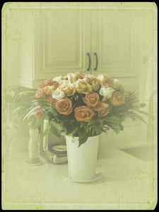 Bouquet of roses on the marble table in a kitchen. Old photo style image