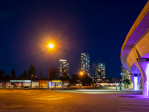 Night cityscape with skytrain rail and bright street light over 
