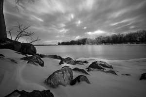 Black and white sunrays over the frozen lake