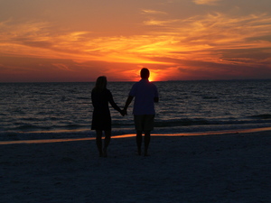 Hand holding walking along the Gulf of Mexico