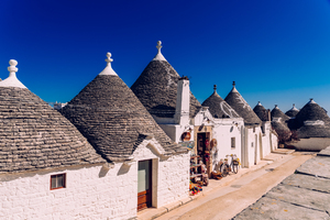 Houses of the tourist and famous Italian city of Alberobello with its typical white walls and trulli conical roofs.