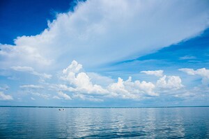 Seascape with bright blue cloudy sky.