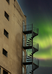 Safety metallic staircase on the building corner with blue sky