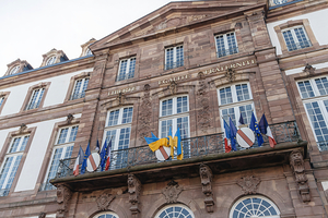 Liberte Egalite Fraternite inscription on the city hall building in Strasbourg with Ukrainian National And French National flags