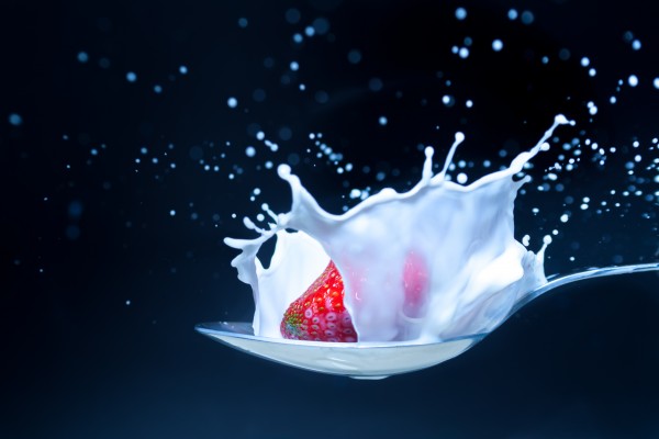 strawberry with milk splash isolated on black by icemanphotos