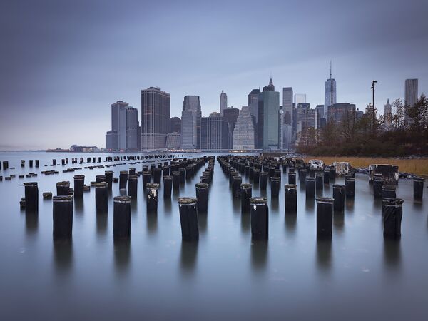 Lower Manhattan Skyline  with pier pilings in east river New York USA by Assaf Frank