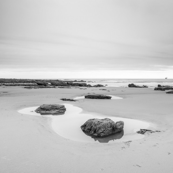 Rock pools on a sandy beach Print