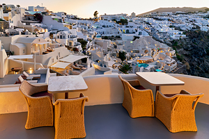 Santorini village at dusk illuminated with outdoor dining terr