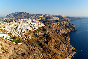 Santorinis white buildings on caldera cliffs above the sea.
