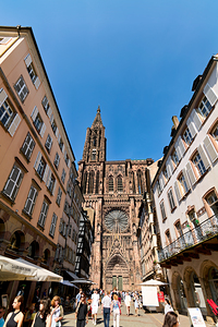 Visitors stroll by the Cathedral in sunny Strasbourg