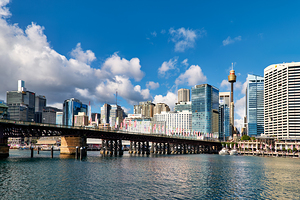 View of Sydney Harbour with bridge and city under blue sky