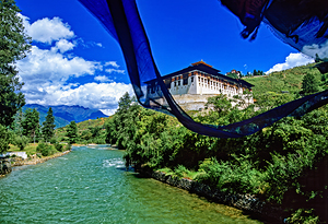 Bhutanese monastery river mountains and prayer flag.