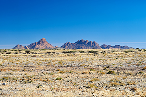 Granite peaks of Spizkoppe rise in Namib Desert landscape
