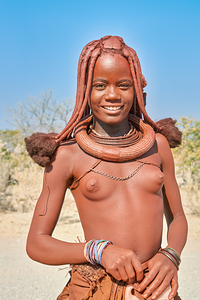Himba woman poses in Kunene region of Namibia during sunny day
