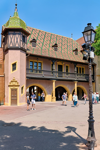 Visitors walk near the historic Koifhus house in Colmar on a sun