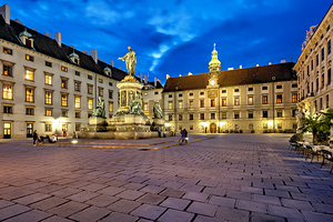 Hofburg Palace square at night with illuminated buildings and st