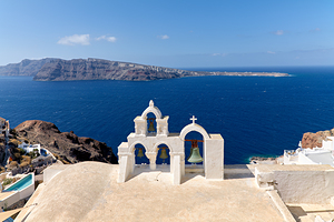 Iconic Santorini bell tower overlooking the caldera and Aegean S
