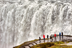 Visitors observe the power of Dettifoss waterfall in Iceland