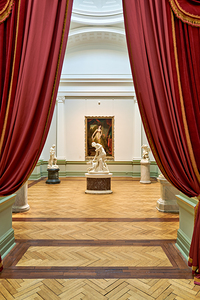 Museum gallery view with art through red curtains in Sydney