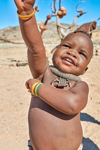 Himba child smiles and poses in the Kunene region of Namibia