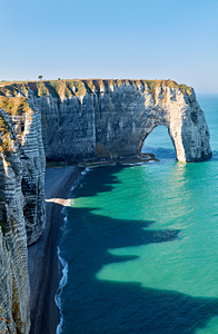 Chalk cliffs of Etretat rise above the blue waters in Normandy F