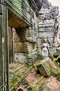 Ancient temple ruins with carved stone deity and moss.