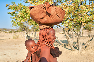 Portrait of Himba woman carrying her baby in Kunene region Nami